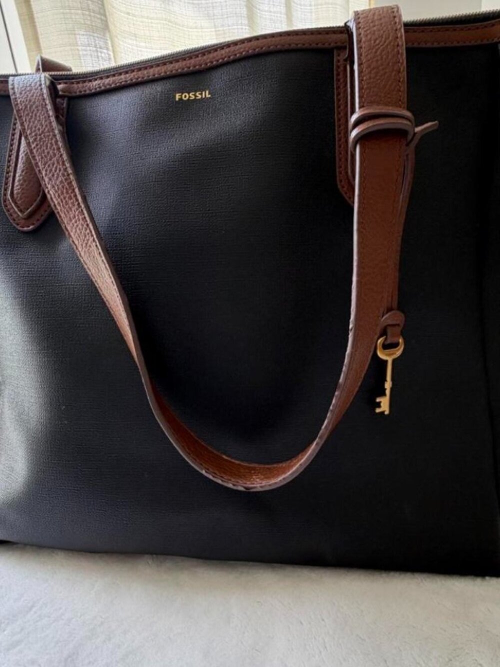 Fossil black tote bag with brown leather accents...